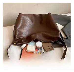 Macro view of deep brown soft leather tote bag showing large interior storage capacity