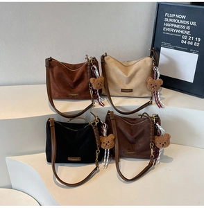 Vue détaillée de quatre sacs cabas vintage en daim marron et beige avec charms d'ours