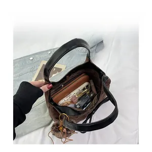 Interior view of brown suede hobo bag with organized compartments for makeup and wallet
