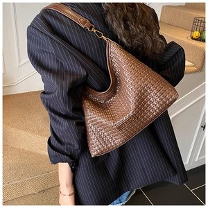 Detailed side view of dark brown woven leather hobo bag with a gold metal buckle