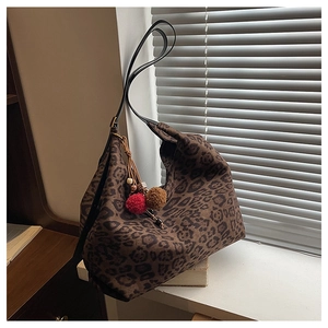 Detail of hobo tote bag with leopard print, leather strap and colorful tassel charm
