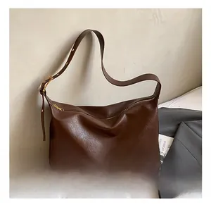 Detailed view of dark brown soft leather tote bag with wide strap and zipper detail