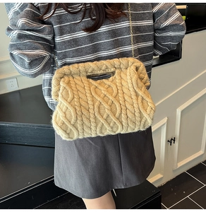 Detail of camel chunky knit shoulder bag featuring braided texture and gold chain strap