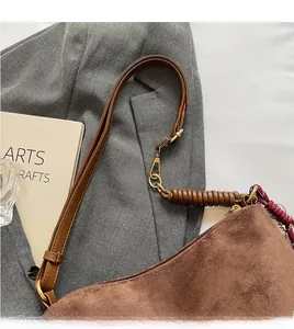 Gros plan du sac fourre-tout en daim marron avec bandoulière réglable en cuir chic