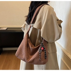 Détail du sac hobo matelassé marron avec breloque raquette de tennis et large bandoulière