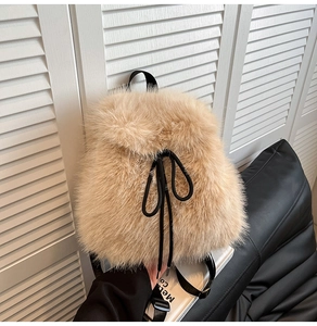 Detail of light brown faux fur backpack with black drawstring closure and soft plush texture