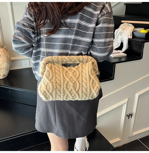 Close-up of beige cable knit cloud bag with a sleek gold chain strap on a model