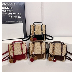 Detail of mini backpacks featuring heart-embossed faux fur and decorative tassel pendants