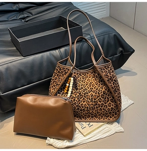 Detail of leopard print suede tote set including a brown pouch and beaded charm