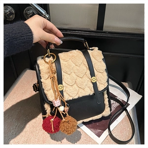Detail view of mini beige faux fur backpack featuring embossed patterns and gold buckles