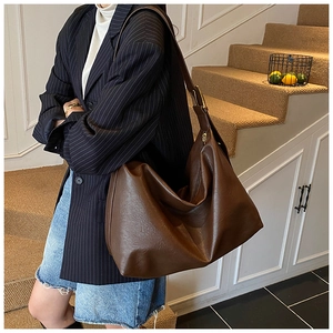 Detail view of large dark brown soft PU leather tote bag with golden metal hardware