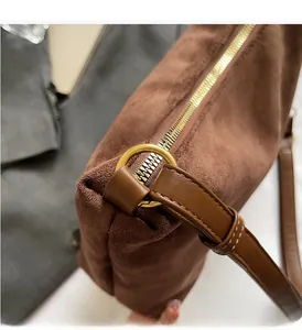 Détail du sac cabas en daim marron avec boucles dorées et surpiqûres de haute qualité