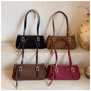 Chic suede underarm bags in black brown coffee and burgundy shown on rustic steps
