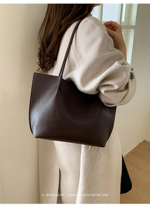 Close-up of deep brown leather tote bag showing high-quality lychee texture and stitching