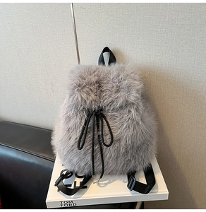 Close-up of grey faux fur backpack featuring plush texture and black nylon drawstrings
