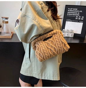 Detail of caramel knit shoulder bag featuring chunky cable texture and gold chain strap