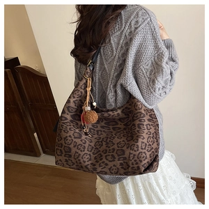Detail of leopard print hobo bag with bohemian charms including tassels and beads