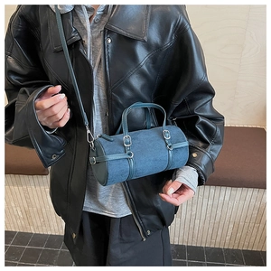 Detail of blue cylinder Boston bag with adjustable strap and matte suede texture
