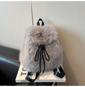 Detail of grey faux fur backpack with drawstring closure and black nylon straps