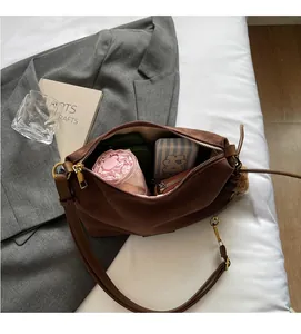 Vue détaillée de l'intérieur spacieux d'un sac cabas en daim marron avec accessoires