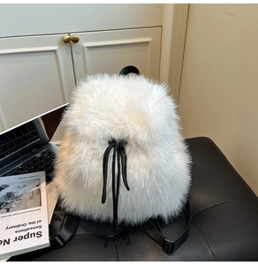 Detail view of the soft white faux fur texture and black drawstring on this plush backpack