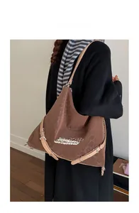 Detail of the brown suede textured backpack featuring stylish straps and printed lettering