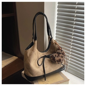 Detailed close-up of khaki suede tote bag with quilted diamond pattern and leopard charm