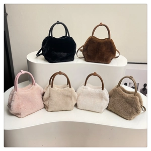 Collection of soft plush handbags in six solid colors arranged on a white display stand