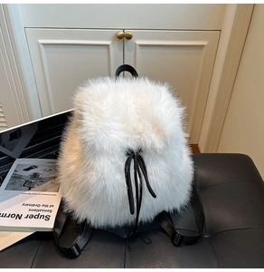 Detailed view of plush white faux fur backpack with black drawstring and textile straps