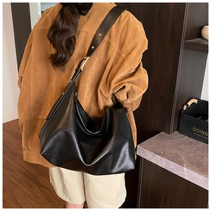Detail of a large black soft leather Hobo bag showing adjustable strap and gold buckle