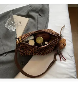 Detail view of leopard print tote bag interior capacity with essentials and brown bear charm