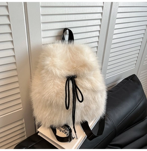 Detail of plush beige faux fur backpack showing black drawstring closure and soft texture