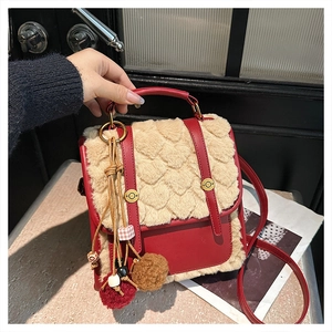 Detail of red and yellow faux fur crossbody bag with heart texture and retro tassel pendant