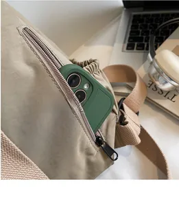 Close-up of khaki nylon backpack side zipper pocket with smartphone storage space