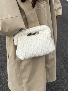 Quilted white chunky knit cloud handbag with gold chain strap shown on model's shoulder