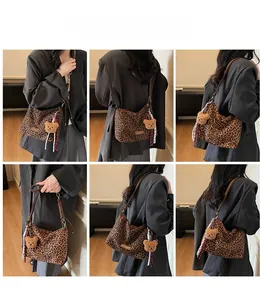 Detail view of leopard print shoulder bag with plush bear charm and silk scarf accent