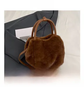 Detailed view of the soft brown faux fur handbag with a leather handle and shoulder strap