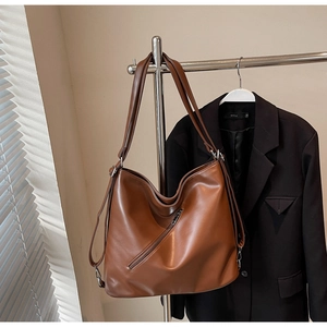 Detailed view of caramel brown faux leather tote bag with functional diagonal zip pocket