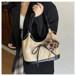 Detail of checkered shoulder bag with black bow and leopard print heart charm