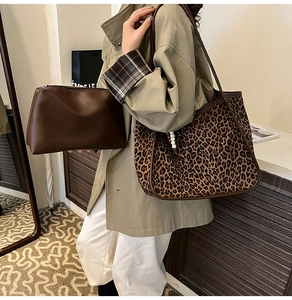Close-up of leopard print tote bag and matching brown pouch with beaded strap details