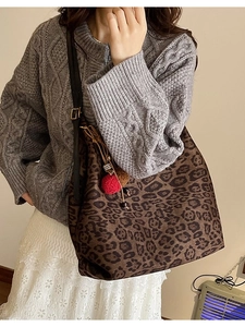 Vintage leopard print tote bag for women with decorative charms worn over the shoulder
