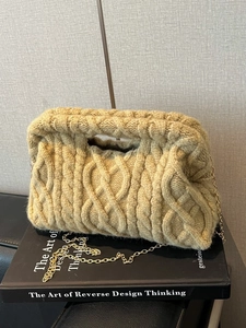 Quilted macaron cosmetic bag with chunky knit texture and elegant gold chain strap