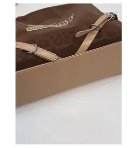 Detail view of large tote bag showing widened bottom and contrast leather texture