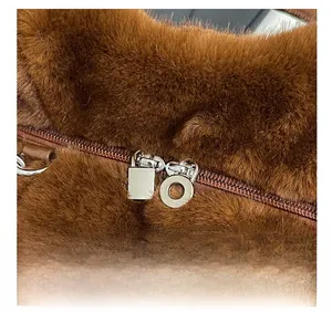 Detailed macro view of dual silver metal zippers on brown faux fur plush crossbody bag
