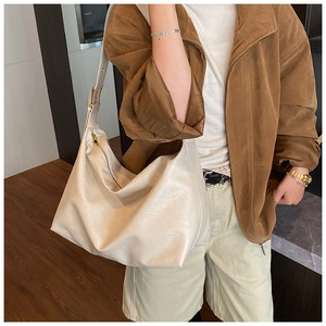 Detail of soft cream white hobo bag with wide shoulder strap and gold metal hardware