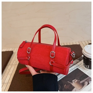 Detail of red suede cylinder bag showing silver hardware and hand-held styling