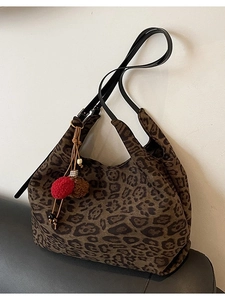 Retro leopard print tote bag with black leather straps and colorful pompom charm