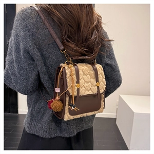 Rear view of a fuzzy brown faux fur mini backpack with heart stitching and cute charms