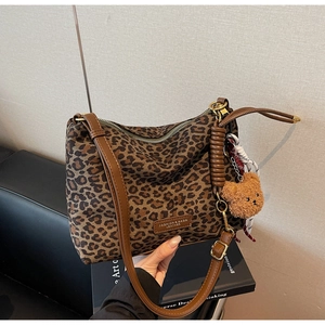 Detail of leopard print tote bag with leather trim and cute brown bear charm