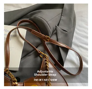 Détail de la bandoulière en cuir réglable et de la chaîne dorée du sac lune marron
